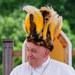 Pape François avec une coiffe ornée de plumes d'oiseaux.